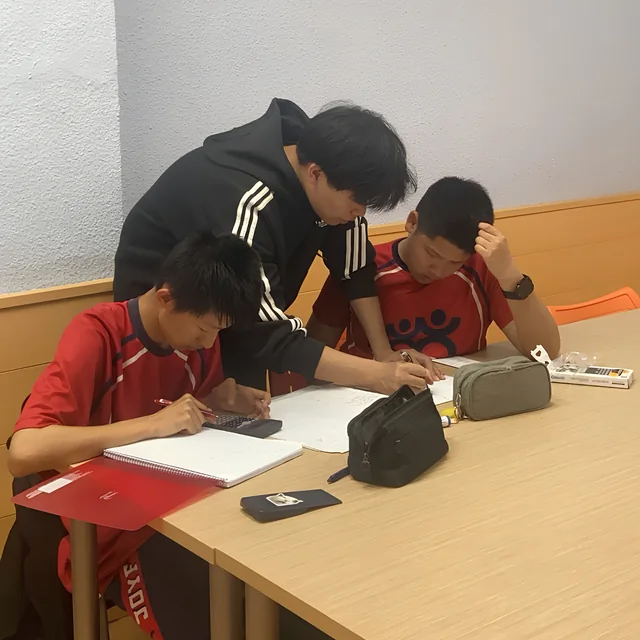 Un profesor corrige el ejercicio de un alumno de ESO.